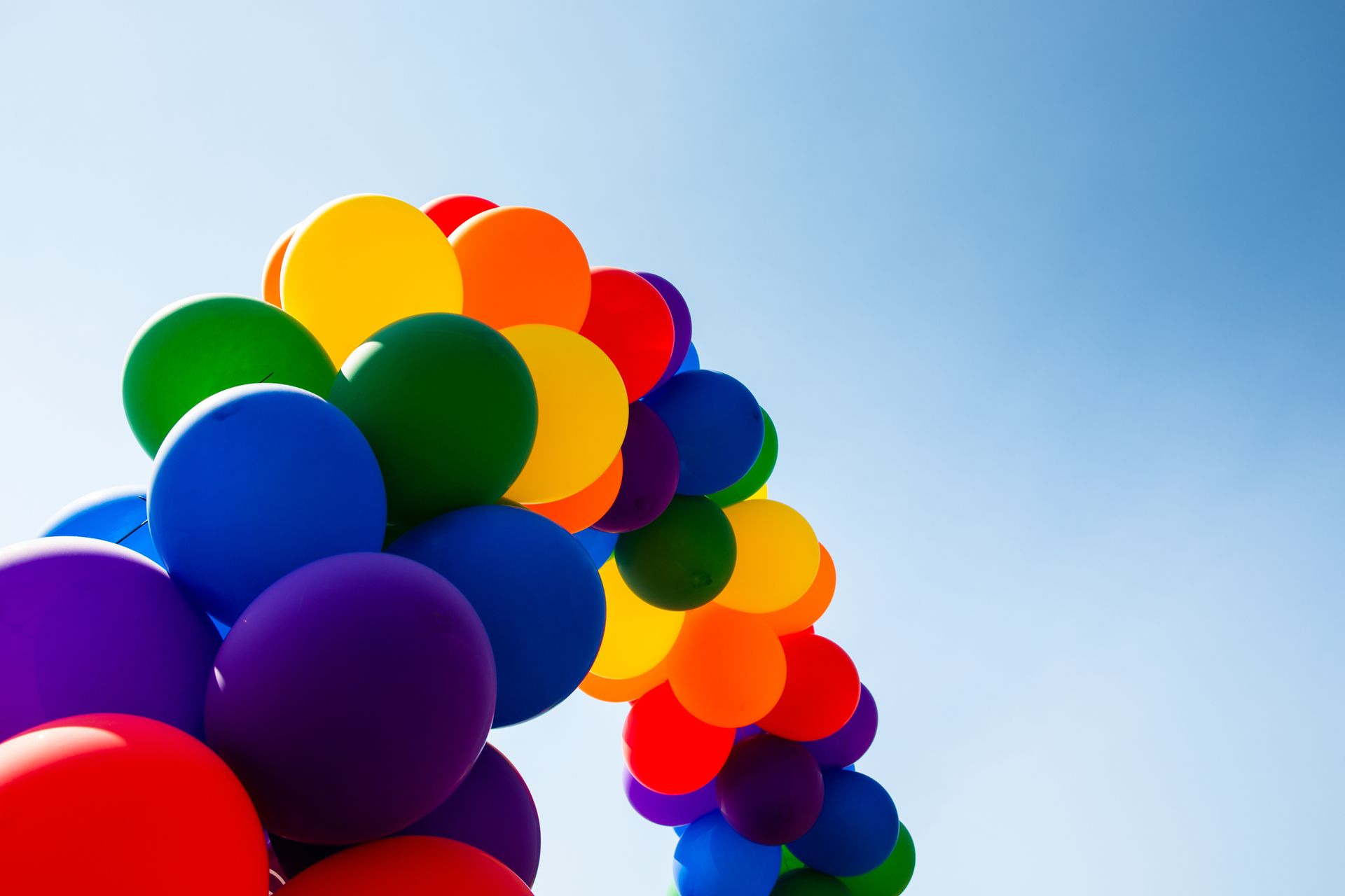Un mazzo di palloncini colorati contro un cielo blu